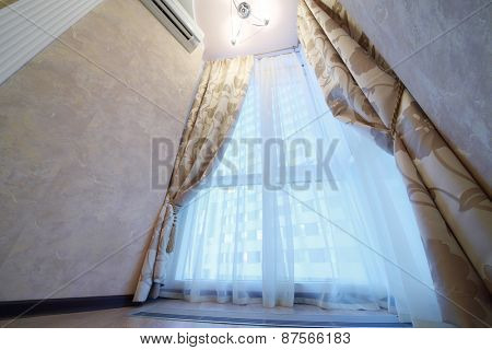 Large window with long curtains in  modern apartment, bottom view