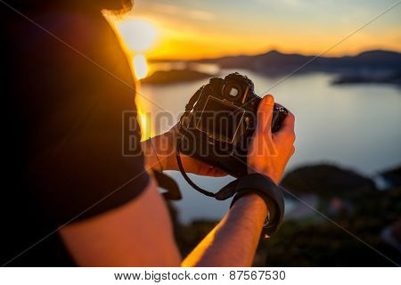 Man photographing sunset on the top of mountain