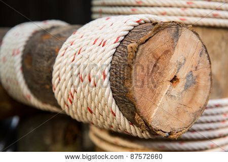 building, construction and eco concept - wooden beam wrapped with rope