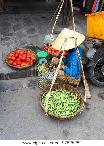 Vietnamese vegetable vendor with baskets