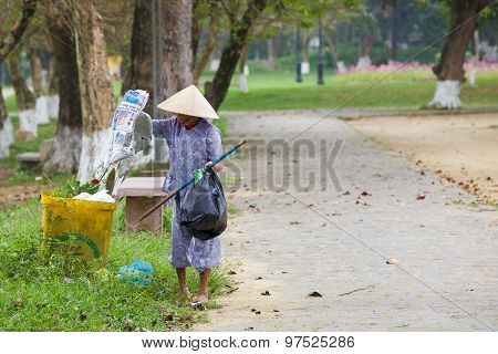 Old woman collects stuff from garbage