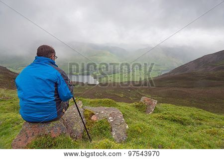 Lone Walker Looks out over Cloudy Mountains