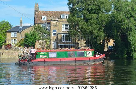 Narrow boat cruising along the river Ouse