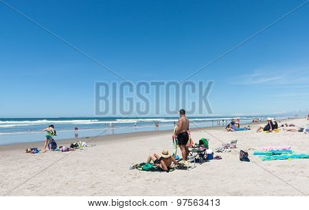 People Enjoying A Summer Day At Beach.