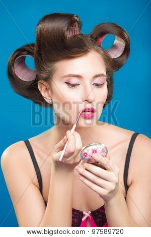 Sexy young pin-up girl doing make-up