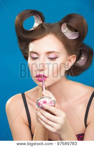 Sexy young pin-up girl doing make-up
