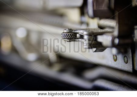 Geared Up; Photo showing a gear mechanism on a 1930's typewriter, with a bokeh background. Background layer suitable for multiple business and industrial applications, advertising or as wall decoration for offices and hotel rooms that cater to a business 