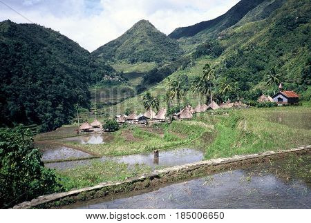 An Ifugao village stands at the bottom of a valley below the ancient rice terraces, carved into the mountains, near the city of Banaue, Ifugao Province, in the Philippines.
