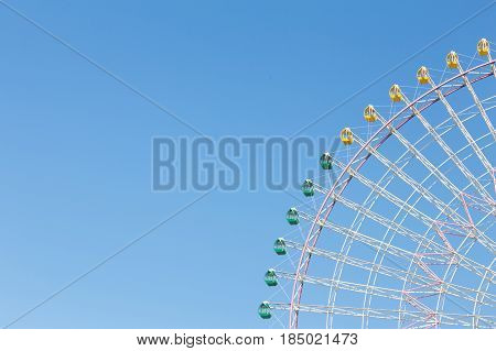 Path of big funfair ferris wheel against clear blue sky background