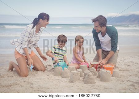 Happy family making sand castle at beach