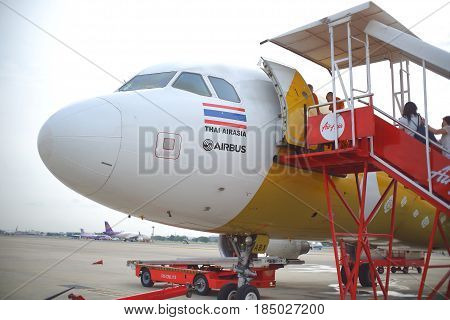 BANGKOK, THAILAND - 30 APRIL 2017: Many passengers going up to a plane with airasia airline at the gate in Don Mueang international airport (DMK)