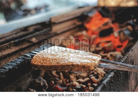 Luleh kebab (minced meat on spits, Middle Eastern staple) being fried on charcoal grill, toned image