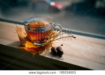 Autumn Still Life: Tea On Maple Leaves On A Wooden Table Near The Window. The Sun's Rays On A Cup Of