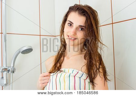 cute young girl with wet volosai in the soul looks straight and smiling close-up