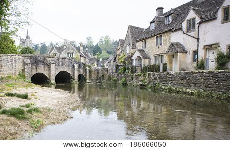 CASTLE COMBE UK - MAY 1 2017: River Bybrook and bridge in Castle Combe Wiltshire UK