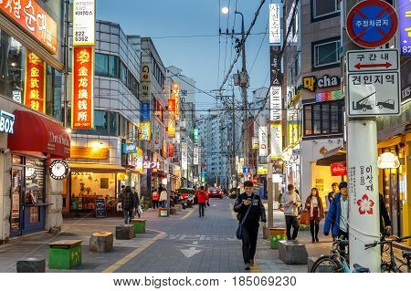 People walking in the street of the Gung-dong shopping and entertainment district at evening Daejeon South Korea 12 March 2017