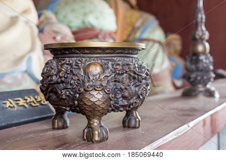 Buddhist temple utensils for religious ritual religious statues of king Dhritarashtra (written in korean) on background. Songgwangsa temple South Korea