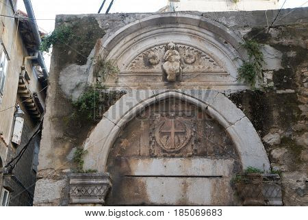 The tymphan on facade of old small church in Split old town, Croatia