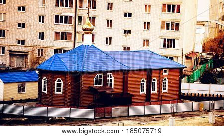 a small chapel on the background of houses.
