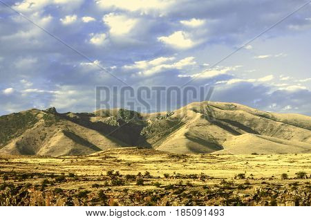 Foothills of the mountains Ara with the impending by the sky thunderclouds clouds in an evening autumn day
