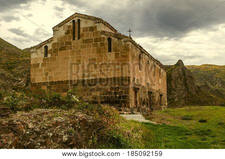 View after the rain on the medieval monastery Tsitsernavank in the autumn overcast day