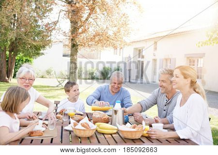 Family of 6 having breakfast together outside the house