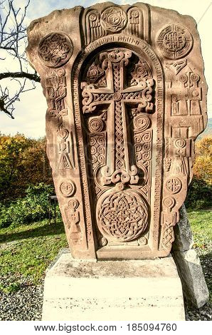 Stone cross monument of reunification Armenian people's in autumn park among trees