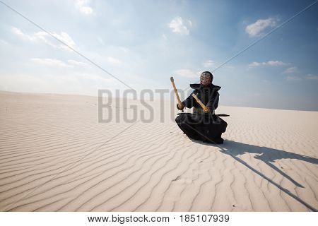 Warrior In Traditional Armor For Kendo Sits With Swords In His Hands