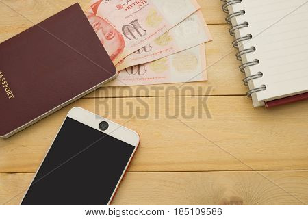 Top View. Singapore Dollar Cash Middle Insert On Passport Book And Have Smartphone And Empty Noteboo