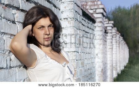 Portrait of a young woman on a brick wall background