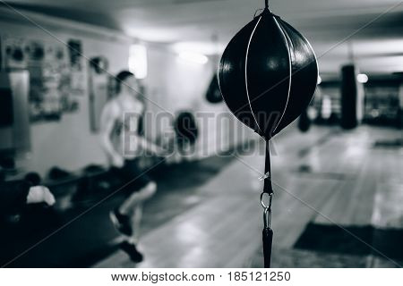 Punching bag in the shape of a ball in the gym. Against the backdrop of athletes.