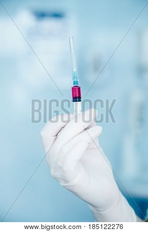 nurse holds a syringe with a universal vaccine against the zik virus, epidemic of ebola, poultry and swine flu, malaria, hepatitis. The concept of saving from disease.