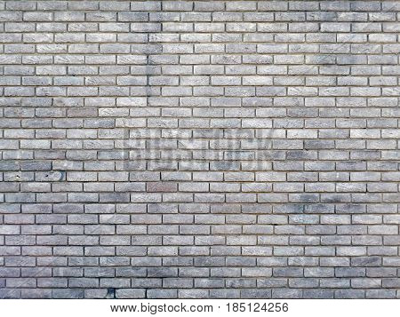 old  grey brick wall with repeating pattern