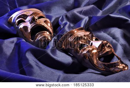 two theatre masks on a blue back round