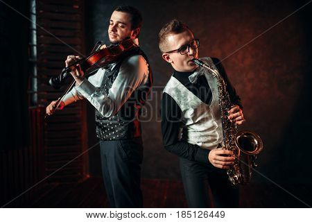 Saxophonist and violinst playing classical melody
