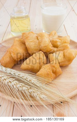 soybean milk in glass and youtiao on wood plate