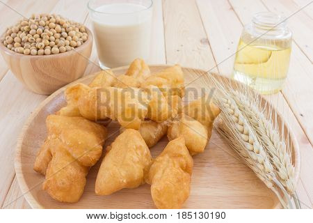 soybean milk in glass and youtiao on wood plate