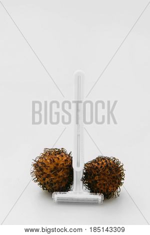 Shaving pubic hair. Intimate zones hairstyle, hygiene, man phallus and balls, pubic hair concept. Two hairy egg with razor on white background, flat lay.