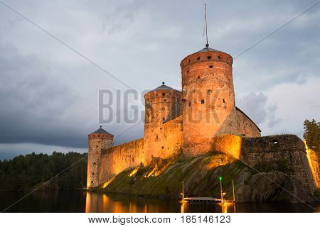 August twilight at the foot of the medieval towers of the Olavinlinna fortress. Savonlinna, Finland