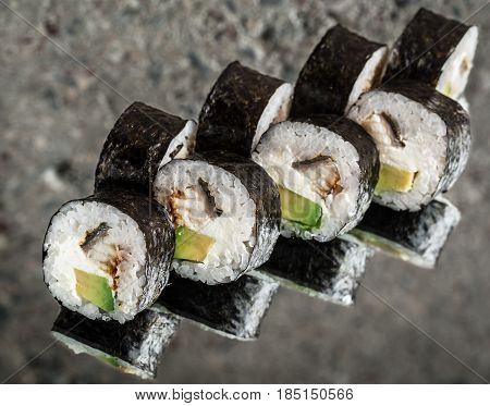 Sushi roll with eel and cream cheese over cocnrete background