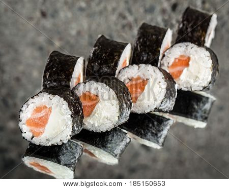 Sushi roll with salmonand cream cheese over cocnrete background