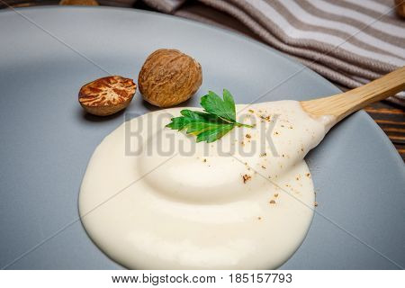 Traditional bechamel and nutmeg on the plate closeup