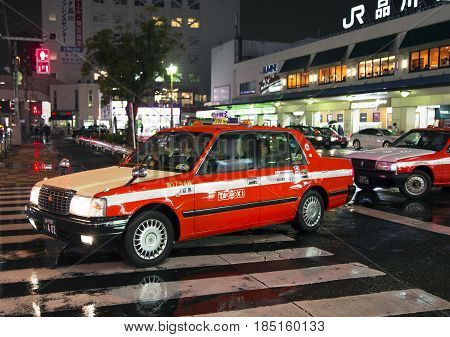 JAPAN, TOKYO, APRIL, 04, 2017 - Tokyo taxi wait for the clients on a rainy evening around Shinagawa Station . Shinagawa-eki is a major railway station in Tokyo, Japan.