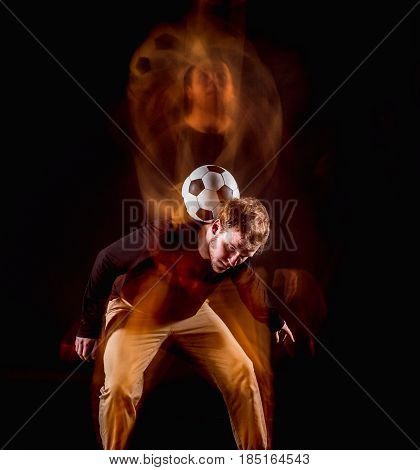 A portrait of a fan with ball on gray studio background. Freestile concept. Stroboscope shooting technique