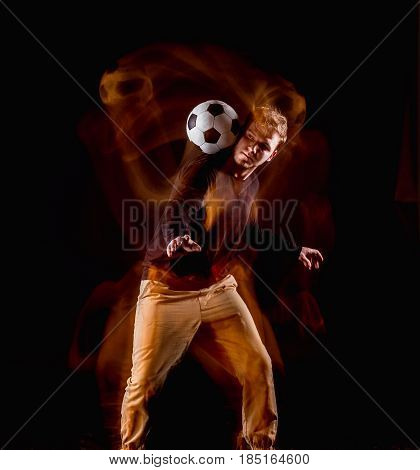 A portrait of a fan with ball on gray studio background. Freestile concept. Stroboscope shooting technique