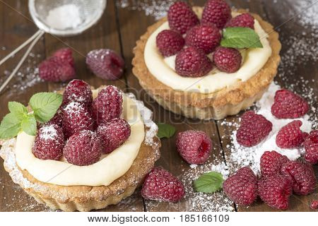 Raspberry tarts with mint and powdered sugar