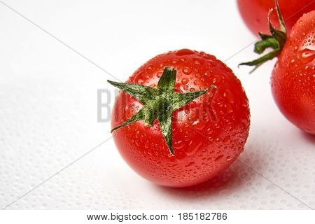 Fresh cherry tomato on white background with waterdrops