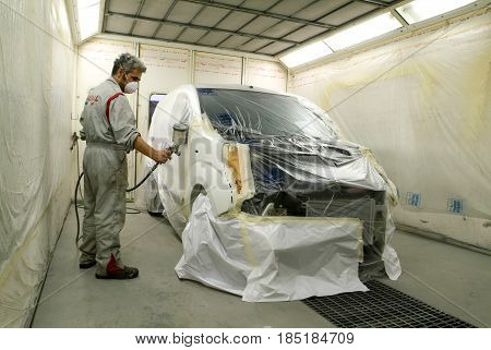 Worker Painting A Car On His Garage