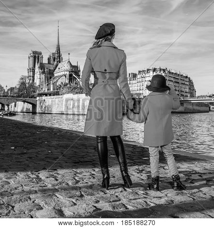 Mother And Child Travellers Standing On Embankment In Paris
