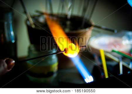 Glass Artist in her workshop making beads in the fire